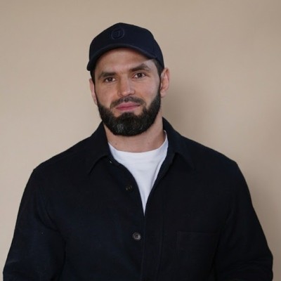 Magomed Kurbaitaev wearing a black cap and jacket over a white T-shirt
